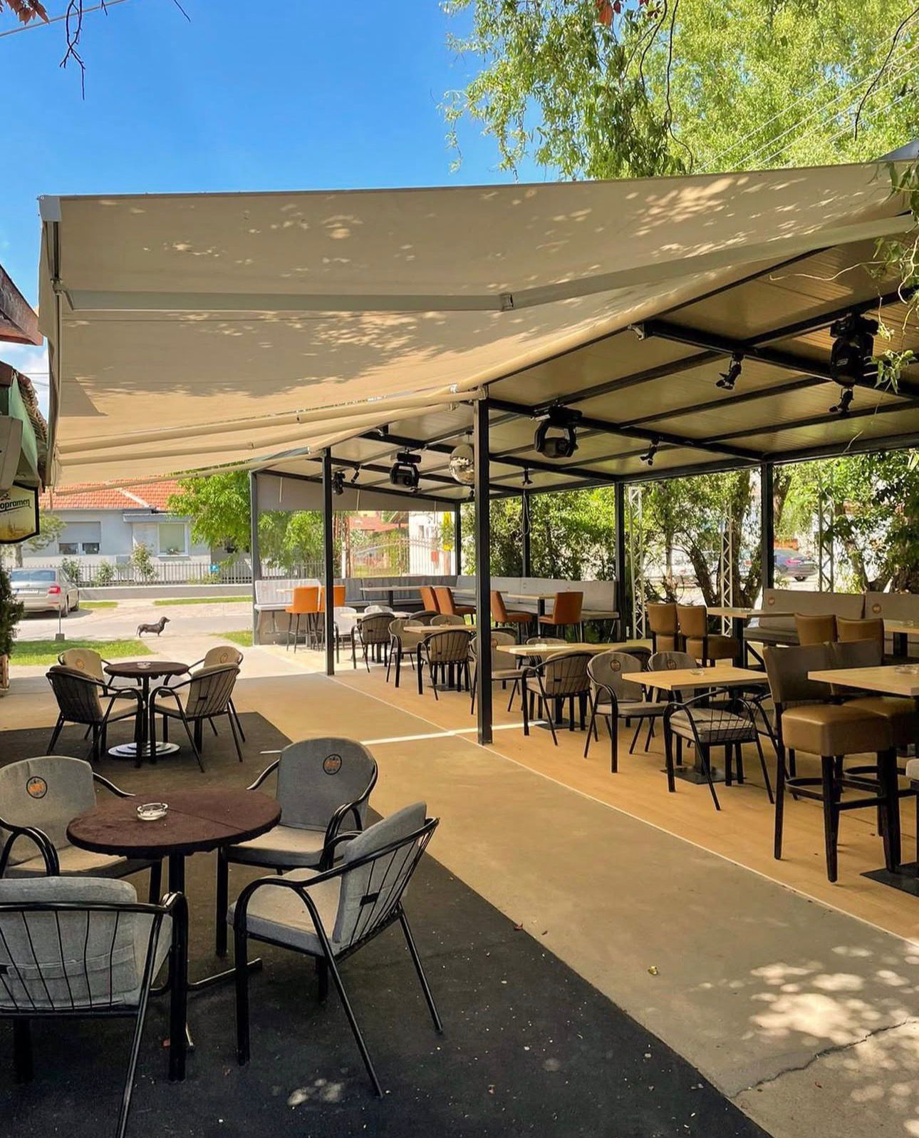 Opuštajuća bašta kafića Caffe Bar Art u Žitištu sa zelenilom i stolovima